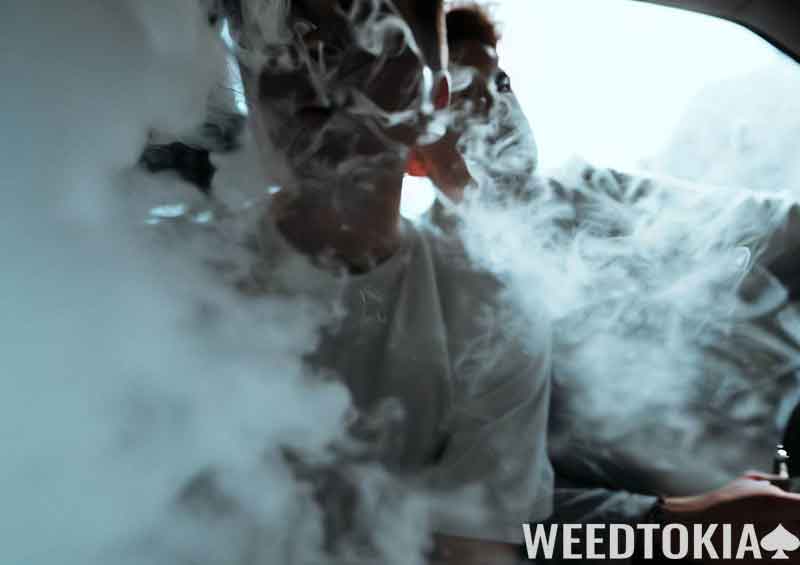 Friends hotboxing in a parking lot